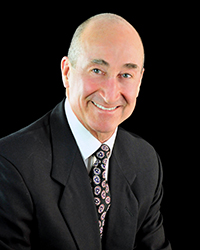 Headshot photo with black background of Mr. E.B. Lowman who is a Board Member for Community Trust and Investment Company.