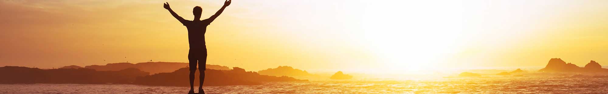 a man raising his arms to the sun