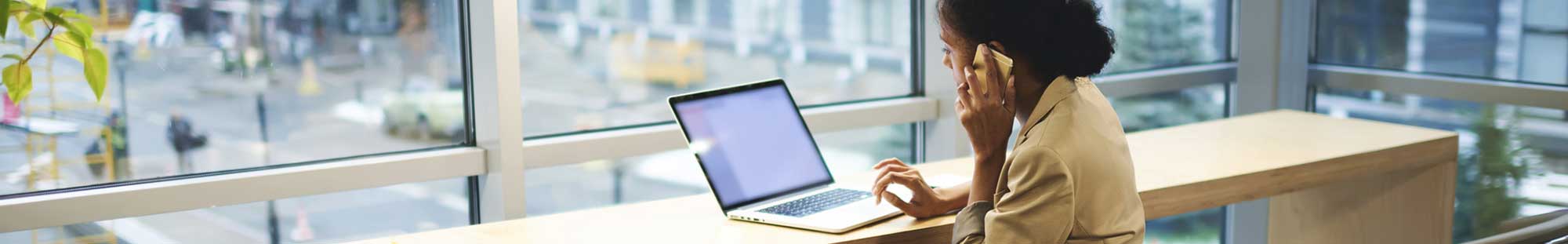 woman using a laptop in a brightly-lit office