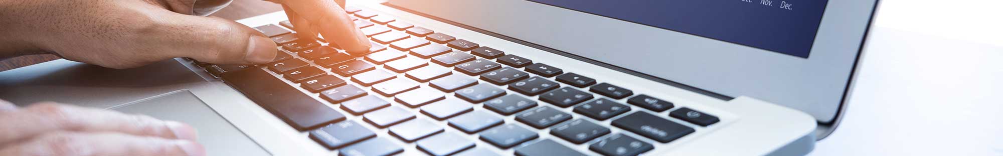a hand typing on a laptop